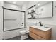 Modern bathroom with wood vanity, open shelving, and shower over tub at 1601 Park Ave # 106, Denver, CO 80218