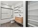 Modern bathroom features shower over tub, wood vanity, and shelving at 1601 Park Ave # 106, Denver, CO 80218