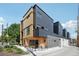 Striking exterior of a modern multi-unit dwelling showcases a mix of wood and gray siding at 1601 Park Ave # 106, Denver, CO 80218