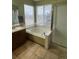 Relaxing bathroom featuring a soaking tub, separate shower, and a large window for natural light at 1517 Stanley Dr, Erie, CO 80516
