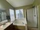 Bright bathroom featuring a tub and shower with a vanity and natural light at 1517 Stanley Dr, Erie, CO 80516