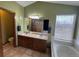 Bathroom showcasing double sinks, vanity, bathtub, and natural light from the window at 1517 Stanley Dr, Erie, CO 80516