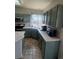 Well-lit kitchen with stainless steel appliances, tiled counters, and painted cabinets at 1517 Stanley Dr, Erie, CO 80516