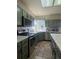 Well-lit kitchen with stainless steel appliances, countertops with tile backsplash, and green cabinets and tiled floor at 1517 Stanley Dr, Erie, CO 80516