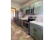Functional kitchen with stainless steel appliances, practical layout and green cabinetry at 1517 Stanley Dr, Erie, CO 80516