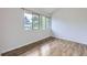 Bright bedroom featuring two windows and beautiful wood-style flooring at 1830 Newland Ct # 209, Lakewood, CO 80214