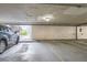 Parking garage featuring assigned parking space with car, brick walls and open access to daylight at 1830 Newland Ct # 209, Lakewood, CO 80214