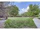 Expansive greenspace featuring a level lawn, mature trees, and walking path at 1830 Newland Ct # 209, Lakewood, CO 80214