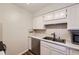 Efficient kitchen space featuring a stainless steel dishwasher and double sink with ample counter space at 1830 Newland Ct # 209, Lakewood, CO 80214