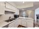 Well-lit kitchen area with stainless steel sink, white cabinetry, and breakfast bar with seating space at 1830 Newland Ct # 209, Lakewood, CO 80214