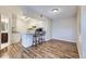 Inviting living space with wood floors, breakfast bar and bar stools leading to the kitchen at 1830 Newland Ct # 209, Lakewood, CO 80214