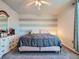 Spacious bedroom with gray bedding, a ceiling fan, and striped accent wall at 2576 S Ensenada Way, Aurora, CO 80013