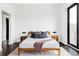 Comfortable bedroom with large window and wood frame bed, with hardwood floors and white rug at 545 Strada Rossa Rd, Golden, CO 80401