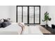 Bright bedroom showcasing patio access, mountain views, and minimalist decor, with hardwood floors at 545 Strada Rossa Rd, Golden, CO 80401