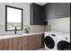Laundry room features sleek black cabinetry, granite countertops, and modern washer/dryer at 545 Strada Rossa Rd, Golden, CO 80401