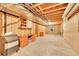 Unfinished basement with exposed beams, a built-in desk, and great potential for customization at 12348 Elizabeth Ct, Thornton, CO 80241