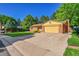 View of charming house on a tree lined street with a yellow garage door at 12348 Elizabeth Ct, Thornton, CO 80241