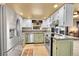 Modern kitchen with stainless steel appliances and green and white cabinets at 12348 Elizabeth Ct, Thornton, CO 80241