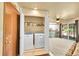 Convenient laundry closet with washer, dryer, and shelving near the kitchen area at 12348 Elizabeth Ct, Thornton, CO 80241