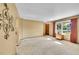 Bright living room with plush carpet and a large window at 12348 Elizabeth Ct, Thornton, CO 80241