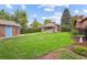 Spacious backyard with grassy lawn, mature trees, and a detached brick shed at 1431 S Emerson St, Denver, CO 80210