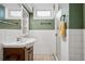Basement bathroom with green walls and white tile at 2042 Jamaica St, Aurora, CO 80010