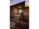 Charming brick home showcasing a cozy covered front porch with wrought iron details at twilight at 2042 Jamaica St, Aurora, CO 80010
