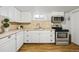 Charming kitchen with white cabinetry, stainless steel appliances, and ample counter space at 2042 Jamaica St, Aurora, CO 80010