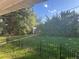 Well-maintained backyard featuring a black metal fence, lush lawn, mature trees, and a shed for storage at 3201 S Albion St, Denver, CO 80222