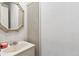 Close-up of a half bath vanity with a marble countertop and classic mirror at 3201 S Albion St, Denver, CO 80222