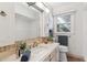 Updated bathroom featuring a marble countertop vanity, decorative plants, and natural light from the window at 3201 S Albion St, Denver, CO 80222