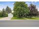 Charming home exterior with a well-manicured lawn, mature trees, and a paved driveway leading to the garage at 3201 S Albion St, Denver, CO 80222