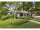 Home's inviting front exterior has a covered porch, tidy landscaping, and mature trees providing ample shade at 3201 S Albion St, Denver, CO 80222