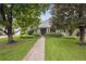 Inviting home exterior features mature trees, lush landscaping, and a walkway to the covered front porch at 3201 S Albion St, Denver, CO 80222