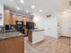 Spacious kitchen featuring an island, tile floors, granite countertops, and black appliances, offering style and functionality at 3662 S Perth Cir # 104, Aurora, CO 80013