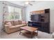 Cozy living room with a comfortable sofa, modern media center, and bright natural light streaming through the window at 3662 S Perth Cir # 104, Aurora, CO 80013
