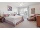 Bright main bedroom featuring carpet, a ceiling fan, a large window, and a cozy sitting area with a leather chair at 3662 S Perth Cir # 104, Aurora, CO 80013
