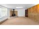 A spacious basement with wood panel accents, a brick fireplace, and a large window for ample natural light at 6953 Ingalls St, Arvada, CO 80003