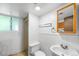 A small bathroom with a toilet, sink, mirror, and shower with a window at 6953 Ingalls St, Arvada, CO 80003