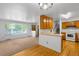 A cozy living room with carpet and a large window, flowing into the kitchen and dining area, great for entertaining at 6953 Ingalls St, Arvada, CO 80003