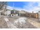 Backyard featuring an elevated deck, partial snow cover, and a fence, creating a private outdoor space at 1517 W Nevada Pl, Denver, CO 80223