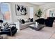 Bright living room featuring a modern sofa, accent chairs, contemporary art, and neutral decor at 1517 W Nevada Pl, Denver, CO 80223