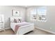 Cozy bedroom with a white frame bed, soft patterned pillows, and bright natural light at 17786 W 86Th Ln, Arvada, CO 80007