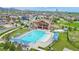 Aerial view of a community pool area with a clubhouse, swimming pool, and lounge chairs at 17786 W 86Th Ln, Arvada, CO 80007