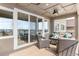 A covered deck features modern outdoor furniture, stylish lighting, and sliding glass doors with neighborhood views at 17786 W 86Th Ln, Arvada, CO 80007