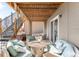 Inviting covered patio with comfortable seating, string lights, and access to stairs at 17786 W 86Th Ln, Arvada, CO 80007