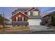 Inviting two-story home with a three-car garage, stone accents, and manicured lawn at 17786 W 86Th Ln, Arvada, CO 80007