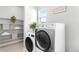 Convenient laundry room with modern washer and dryer, shelving, and ample storage at 17786 W 86Th Ln, Arvada, CO 80007