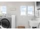 Functional laundry room with modern washer and dryer, sink, and natural light at 17786 W 86Th Ln, Arvada, CO 80007