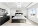 Bright main bedroom boasts large windows with neighborhood views, tray ceilings, and modern decor at 17786 W 86Th Ln, Arvada, CO 80007